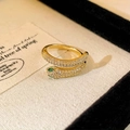 Macro detail van gouden slangenring met witte zirkonia en opvallende groene edelsteenogen - Goud Met Groene Ogen (Echt Verguld)