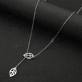 Detail shot of silver leaf pendant necklace featuring intricate hollow and solid engravings - Steel Double Leaf