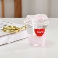 Detalle de un llavero con forma de corazón con líquido rosa y anillo dorado - Corazón-Copa de Corazón