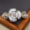 Pince à cheveux papillon élégante avec zircons brillants sur base en métal doré - Fleur à Trois Pétales