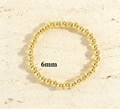 Detailed view showing 6mm 18K gold-plated beads on a minimalist elastic bracelet - 6mm