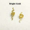 Close-up of bright gold hollow snake-shaped hair rings with detailed metallic texture - Bright Gold