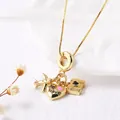 Golden travel necklace with airplane, camera and heart pendant on white fabric background - Airplane Camera Heart (Style B)