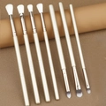 Gros plan de 7 pinceaux de maquillage pour les yeux professionnels aux manches dorés champagne - Bleu foncé