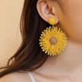 Dettaglio di orecchini a girasole intrecciati oversize in giallo con trama in rafia - Girasole intrecciato giallo (8# Perno in acciaio)