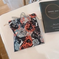 Detail of floral drawstring pouch with orange roses and a grey hair claw clip - Black With Rose