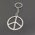 Close-up of a silver metal keychain with a minimalist peace symbol pendant on dark surface - Antique Silver