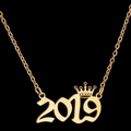 Detailed macro of gold 2019 number pendant with crown decoration on a cross chain - 2019 / Gold