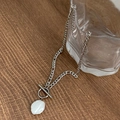 Detailed close-up of baroque pearl pendant and silver OT toggle clasp on necklace - Silver