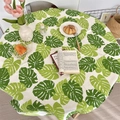 Dettaglio tovaglia rotonda in cotone e lino con stampa monstera verde in ambiente casa - 90*90cm / Foglia di Monstera verde