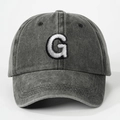 Detailed close-up of dark grey washed cotton baseball cap with white letter G embroidery - Letter G