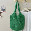 Green crochet woven tote bag with hollow out pattern hanging on a wall hook - Green