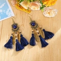 Detailed view of Bohemian gold feather earrings with dark blue tassels on wood - Ink Blue Gem Tassel