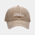 Detail der 'hello Sunshine' Stickerei auf einer gewaschenen braunen Vintage-Basecap - Khaki