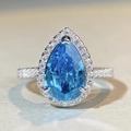 Macro di un anello in argento con gemma blu a goccia e alone di diamanti scintillanti - US 5 / Strass Blu (CBJZ274)