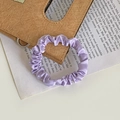 Elegant purple satin scrunchie with soft sheen on a vintage leather and paper background - Taro Purple