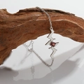 Detail showing silver heartbeat necklace with red gemstone on artistic wooden branch - Silver Natural Garnet Bracelet