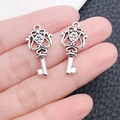 Pair of vintage silver alloy key pendants shown on fingers for actual size scale - Hanging Hole Key (6863)
