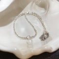 Elegant pearl necklace with silver碎银 chain and crystal charm in a shell bowl - Silver White
