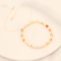 Detail of bohemian woven bracelet with natural stones and adjustable beaded string - White