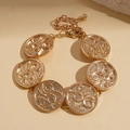Close-up of golden geometric textured round links on bracelet with lobster clasp detail - Gold