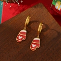 Weihnachtliche rote Emaille-Handschuh-Ohrringe aus 18K vergoldetem Edelstahl auf Holzgrund - Weihnachtshandschuhe