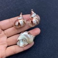 Natural sea shell pendants with rose gold plated edges held in hand for jewelry making - No.1 (Iridescent Shell - Rose Gold Edge)