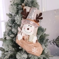 Christmas stocking with sequins and reindeer hanging on a snowy Christmas tree - Christmas Reindeer