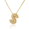 Detailed macro view of gold letter S pendant necklace with micro-paved sparkling zircon - Letter S