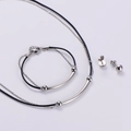 Set gioielli minimalista argento con collana bracciale ed orecchini su sfondo grigio - Set (AML-MSA-TZ-122) / Color Acciaio