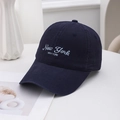 Casquette de baseball en coton bleu marine avec broderie sur un bureau blanc - Bleu marine
