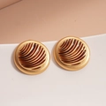 Macro view of vintage geometric round stud earrings with gold trim and brown wavy texture - Gold