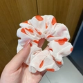 White organza scrunchie with orange polka dots featuring a soft iridescent mermaid laser finish - Red Heart