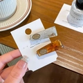 Elegant marble and amber acetate hair clips set with golden metal logo accents - Grey + Amber (Pair)
