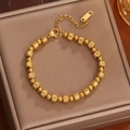 Bracciale in titanio placcato oro 18K con perline testurizzate visto a 45 gradi - Oro