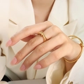 Poliertes goldenes Knotenring- und Armband-Set, präsentiert auf einem beigen Blazer - US 6 / Knoten Ring / Gold