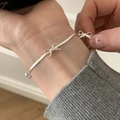Minimalist silver bow bracelet with delicate link chain and 3D bow charms on female wrist - Bow Embellished Style (SL1348)