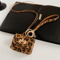 Vue détaillée d'une pochette léopard avec porte-clés doré et dragonne assortie - Collier Mini Sac Imprimé Léopard / Café Clair