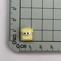 Detailed size view of yellow resin toast charm with big eyes on a centimeter scale mat - 12*Toast Bread Mini