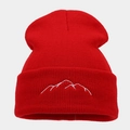 Close-up of red knit beanie featuring white mountain embroidery on the folded cuff - Red