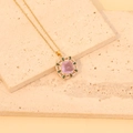 Collier vintage doré avec pierre rose et cristaux verts sur un socle en pierre texturée - 2# Violet
