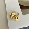 Dettaglio ravvicinato dell'anello in ottone dorato con design a onde e finitura lucida - Aperto Regolabile / Anello a Gonna d'Oro