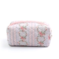 Close-up of pink floral quilted makeup bag with soft fabric and durable zipper detail - Blue