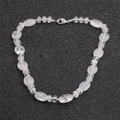 Gros plan de perles en quartz translucide et fermoir mousqueton sur fond noir scintillant - Style Cristal Clair (NSN0214)