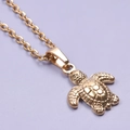 Macro detail of golden turtle pendant and minimalist stainless steel chain necklace - Gold Necklace