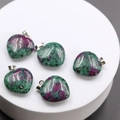 Set of five heart-shaped natural Ruby Zoisite stone pendants on a white display - Ruby Zoisite