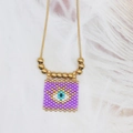 Detail shot of the woven evil eye square pendant on a golden beaded chain necklace - Purple