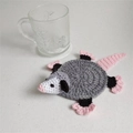 Handmade crochet opossum coaster in grey and white yarn for tabletop protection - Straight Tail Mouse