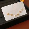 Close-up of golden earring set with heart, cube and X designs on display card - Gold with Silver Needle (6-Piece Set)