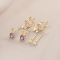 Vue détaillée des boucles d'oreilles lapin avec pierres de zircone violettes, roses et blanches - Lot de 3 paires / Doré